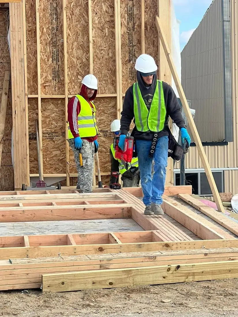 Framing crew in safety vests on a new wood frame build